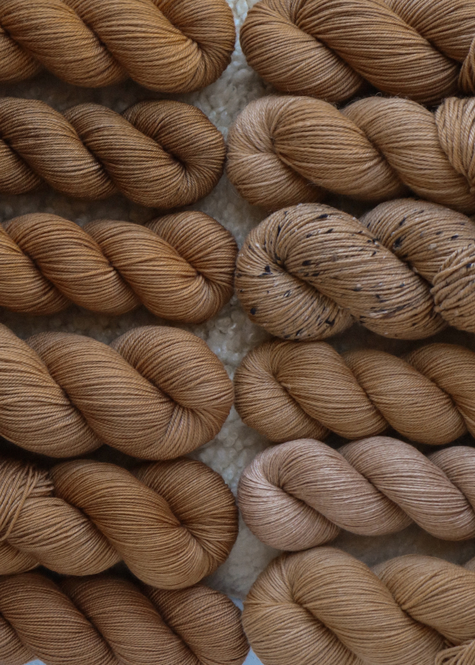 Close-up of brown yarn skeins on a textured surface