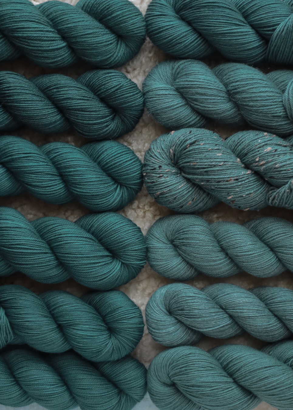 Close-up of teal yarn skeins on a textured surface