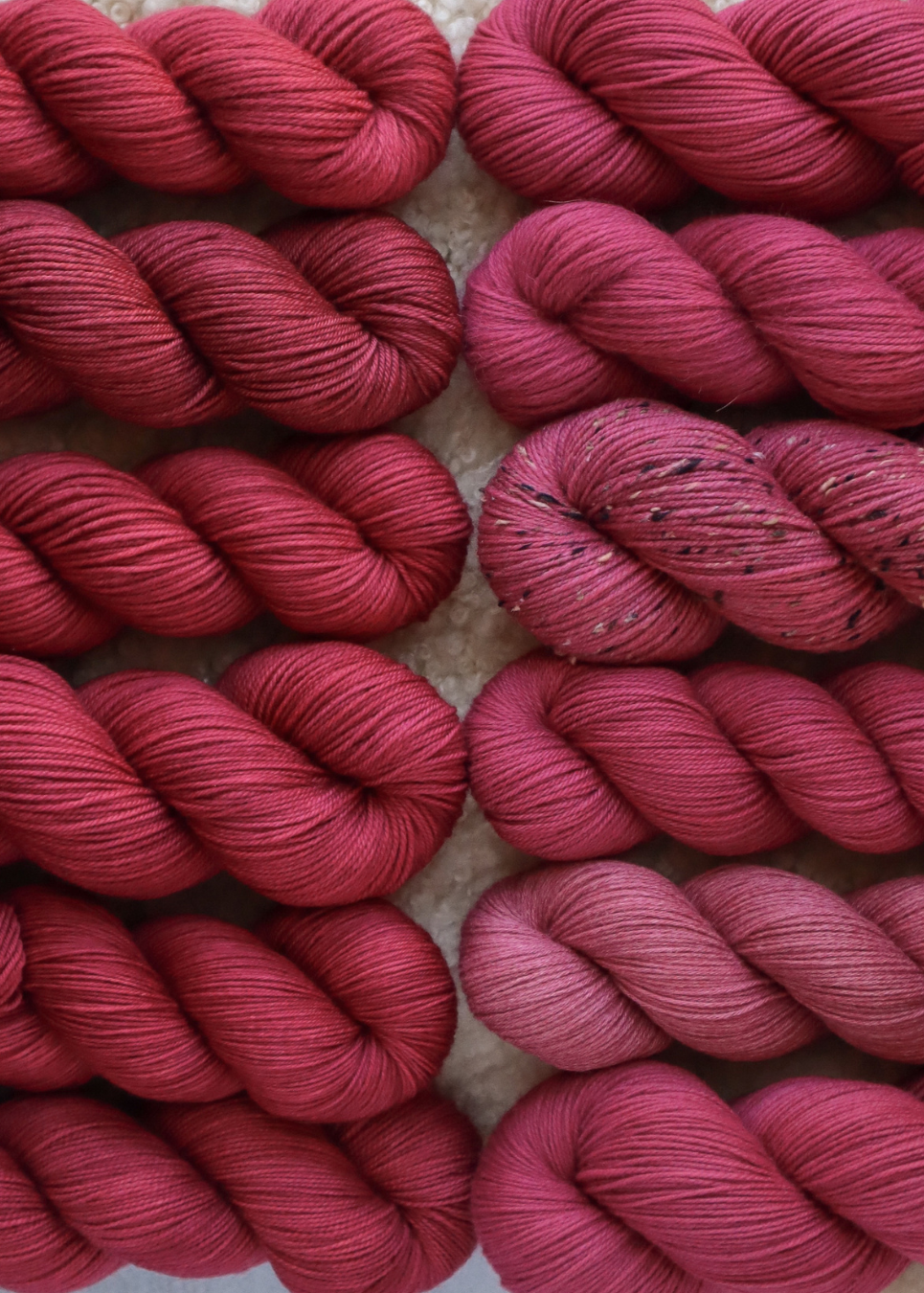 Pink yarn skeins on a textured surface