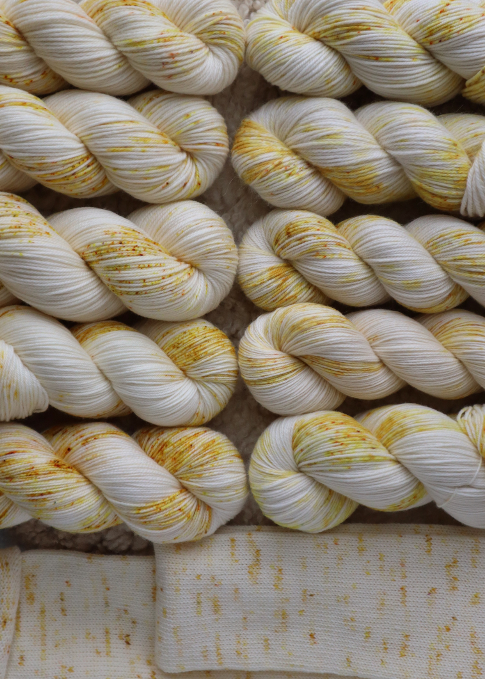 Close-up of white and yellow yarn with a textured background