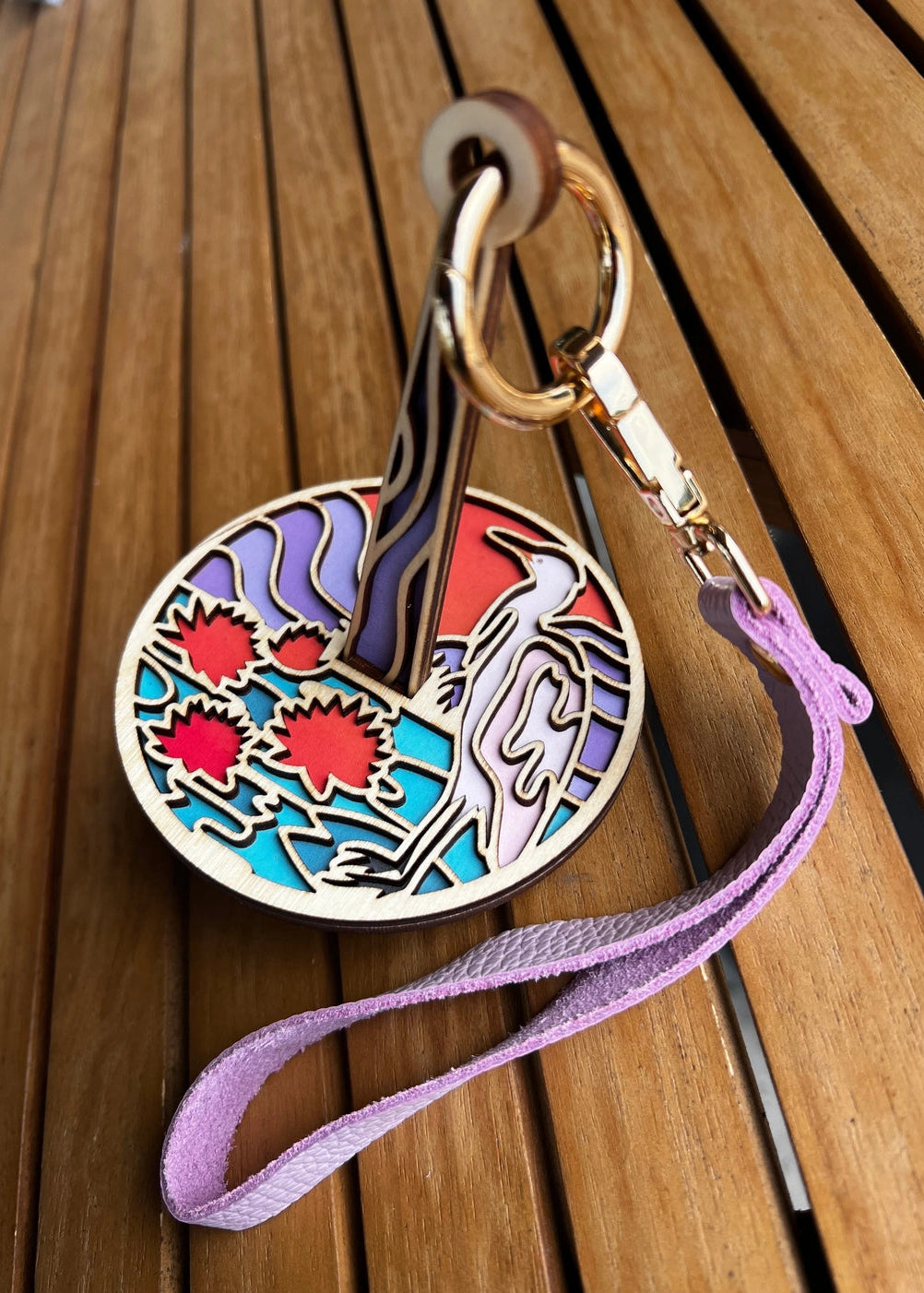 Colorful keychain with artistic design on a wooden surface
