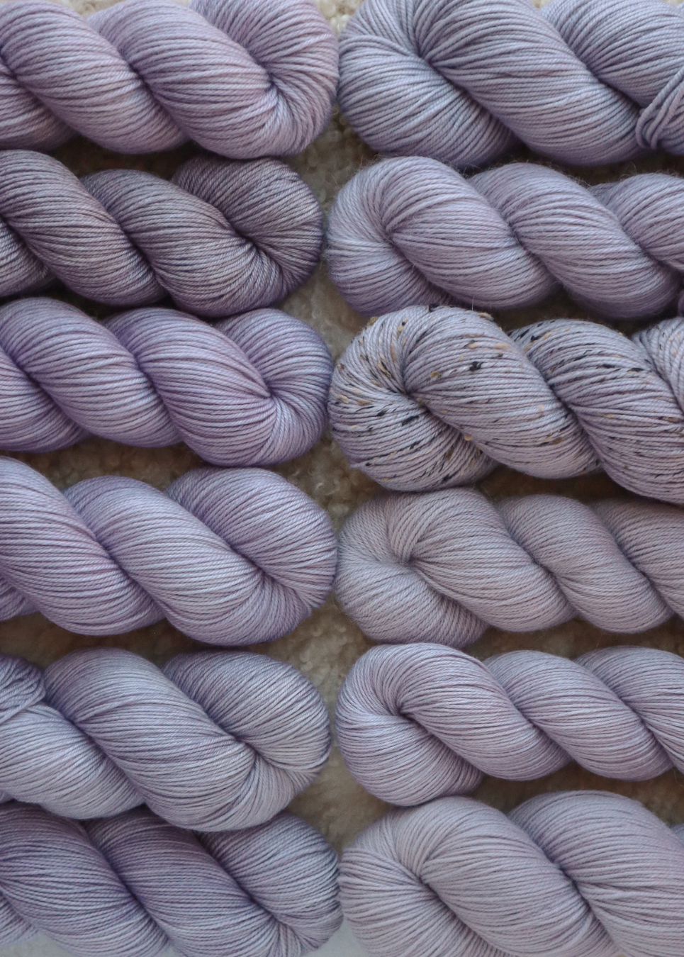 Close-up of skeins of purple yarn on a textured surface