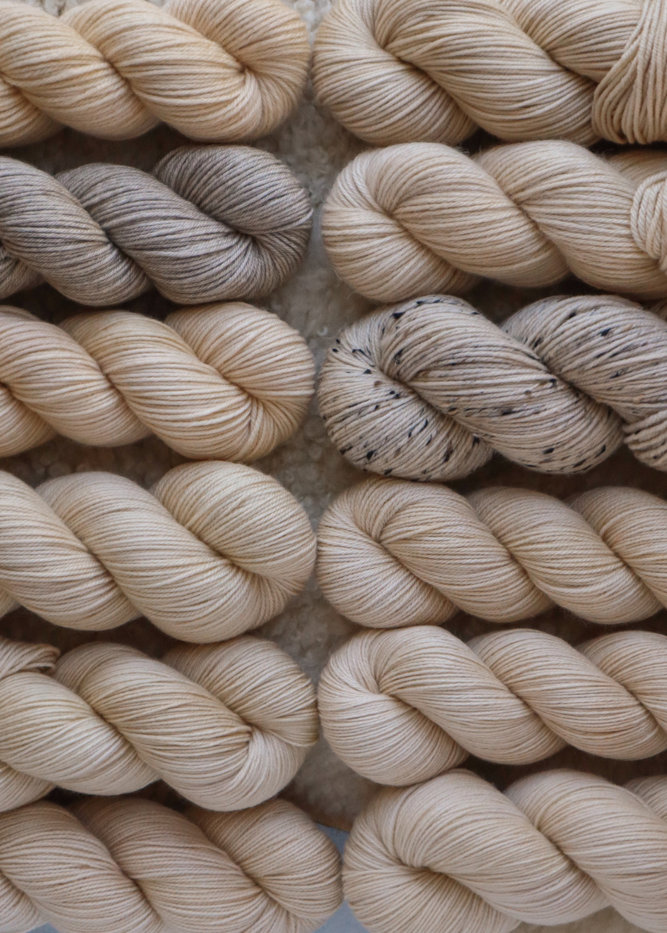 Close-up of beige yarn skeins on a textured surface