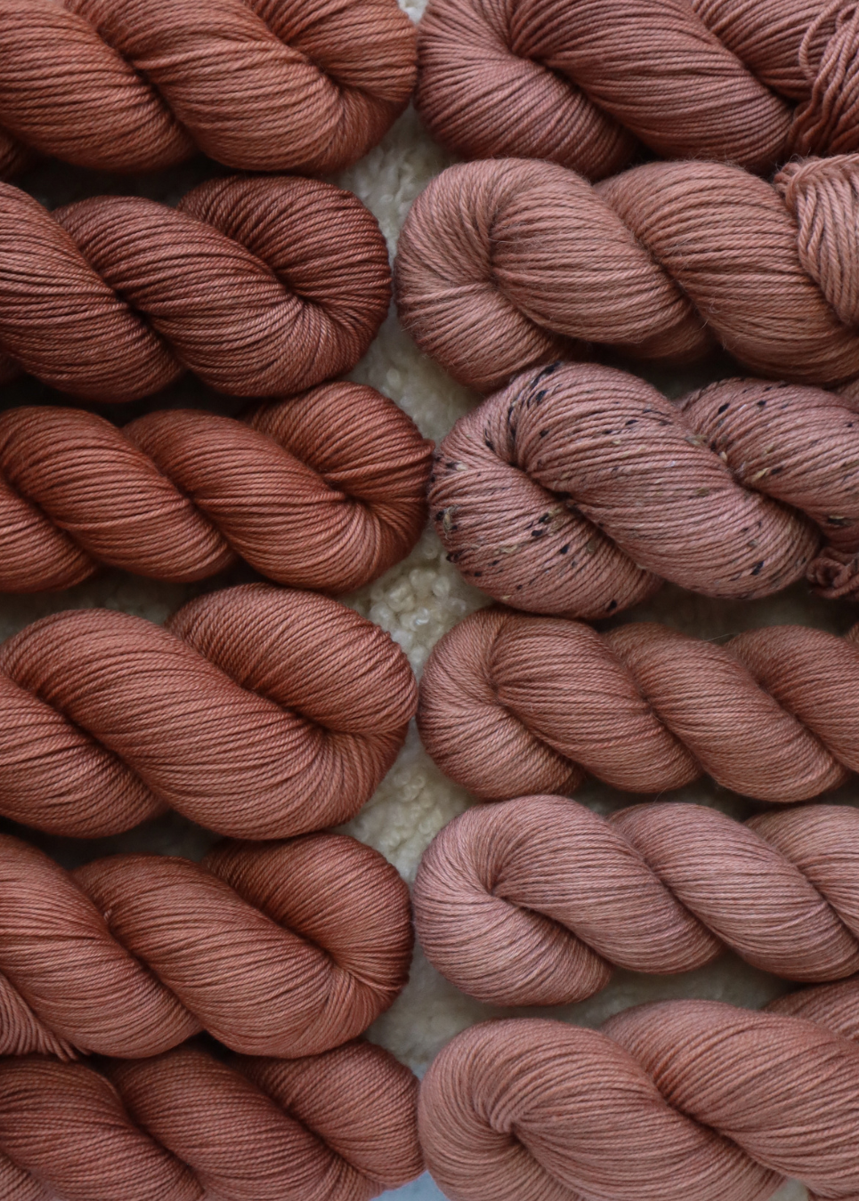 Close-up of skeins of pink yarn on a textured surface